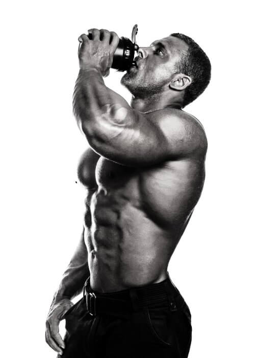 Bodybuilding athlete sipping supplement